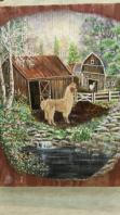 Close up photo of a painting of a llama in front of a barn