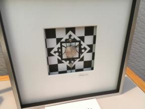 Photo of six inch silver frame with an arranged silver piece within.