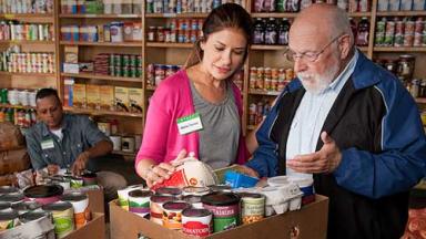 A food pantry staff member helps a client with his selections.